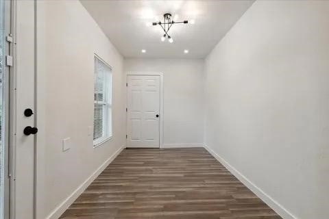 entryway featuring an inviting chandelier and dark hardwood / wood-style floors