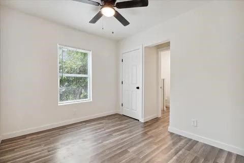 empty room with hardwood / wood-style flooring and ceiling fan