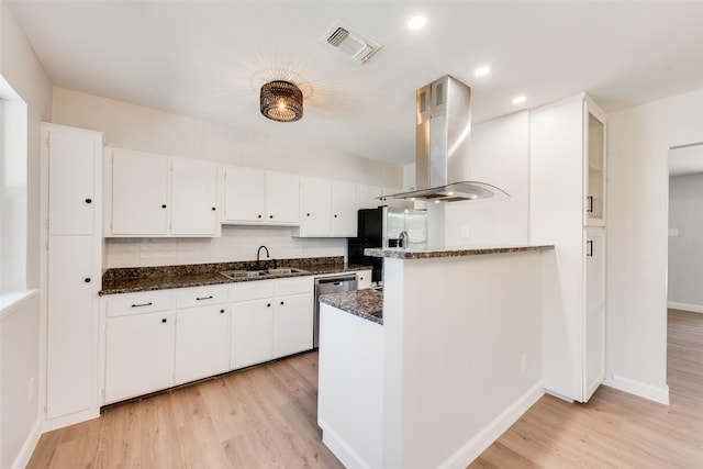 kitchen featuring visible vents, island range hood, fridge with ice dispenser, white cabinetry, and a sink