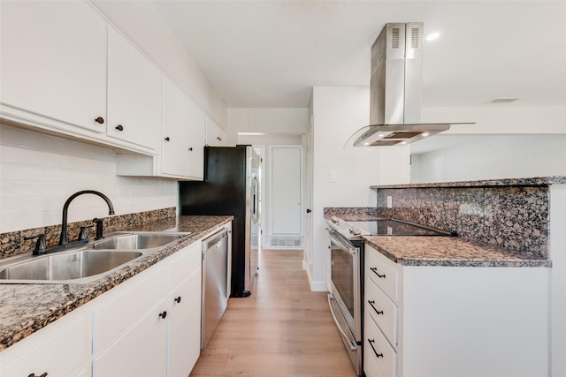 kitchen featuring a sink, visible vents, ventilation hood, appliances with stainless steel finishes, and backsplash