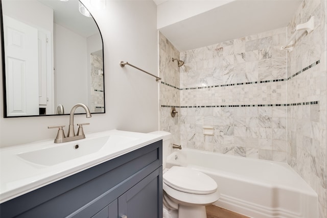 full bathroom with tiled shower / bath, vanity, wood-type flooring, and toilet