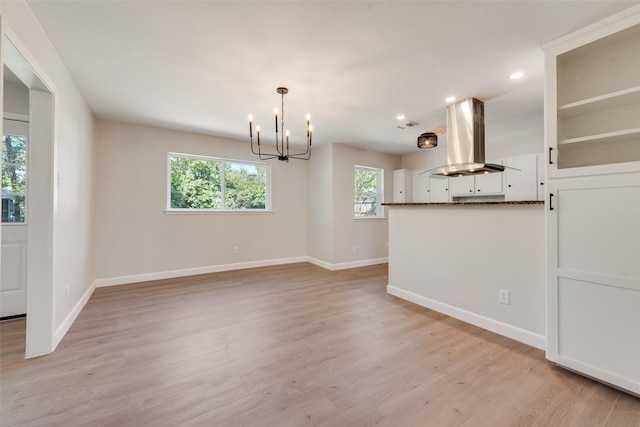 interior space with light wood-style flooring, baseboards, and a notable chandelier