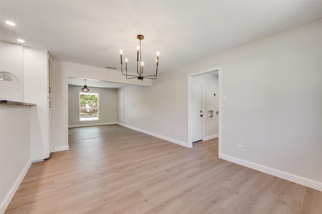 unfurnished dining area featuring light hardwood / wood-style flooring and a chandelier