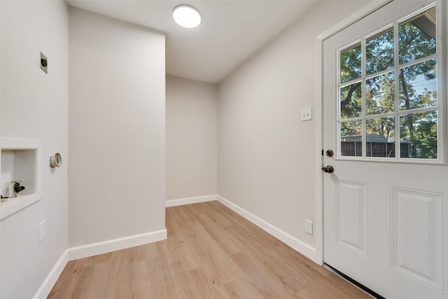 doorway featuring light wood-style flooring and baseboards