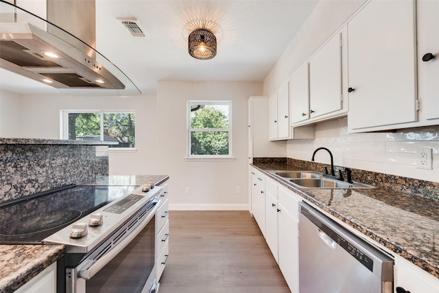2511 Larchmont Dr, Mesquite, TX 75150 - kitchen featuring appliances with stainless steel finishes, extractor fan, a sink, tasteful backsplash, and light wood finished floors