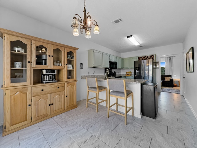 kitchen with green cabinets, stainless steel fridge with ice dispenser, a notable chandelier, decorative light fixtures, and light stone counters