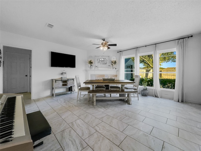 unfurnished dining area featuring a textured ceiling and ceiling fan