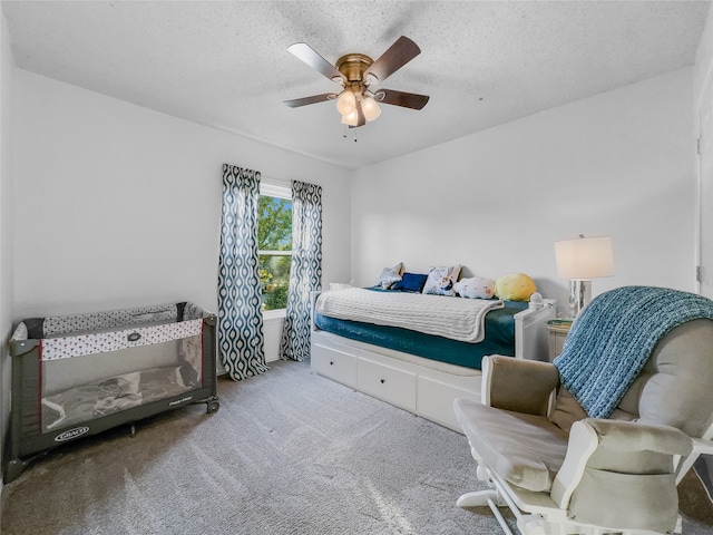 carpeted bedroom featuring a textured ceiling and ceiling fan