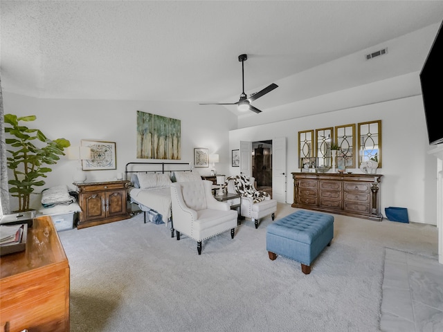 carpeted bedroom with vaulted ceiling, a textured ceiling, and ceiling fan