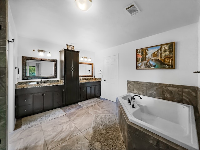 bathroom featuring vanity and tiled bath