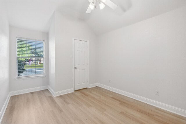 empty room with light wood-type flooring, ceiling fan, and lofted ceiling