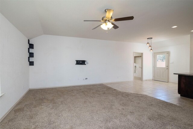 empty room with light carpet, a ceiling fan, baseboards, and light tile patterned floors