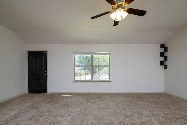 spare room featuring lofted ceiling, light colored carpet, and ceiling fan