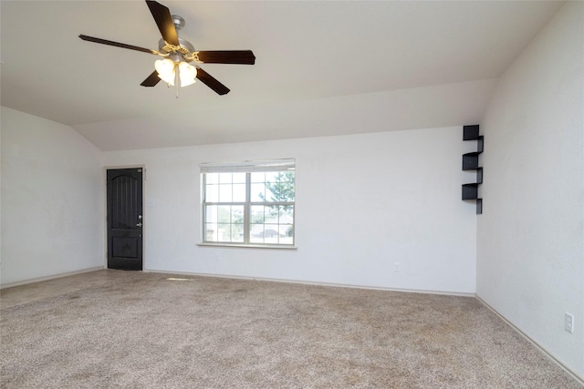 unfurnished room featuring ceiling fan, vaulted ceiling, baseboards, and carpet