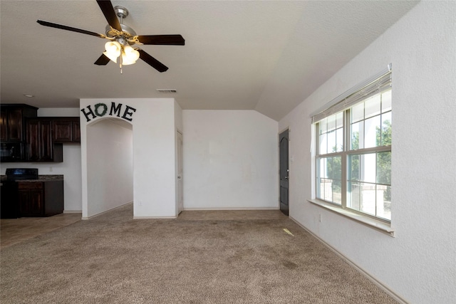 unfurnished living room featuring light colored carpet, vaulted ceiling, a ceiling fan, and visible vents