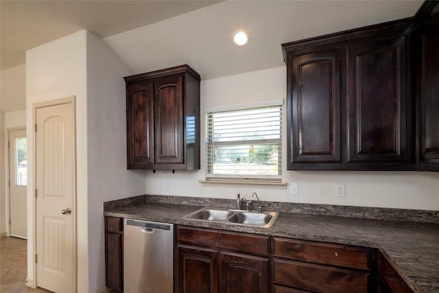kitchen featuring dark brown cabinetry, dark countertops, stainless steel dishwasher, and a sink