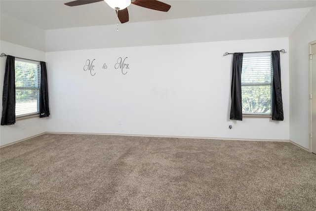 unfurnished room featuring plenty of natural light, a ceiling fan, and carpet