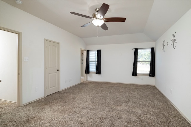 unfurnished bedroom with ceiling fan, multiple windows, carpet, and lofted ceiling