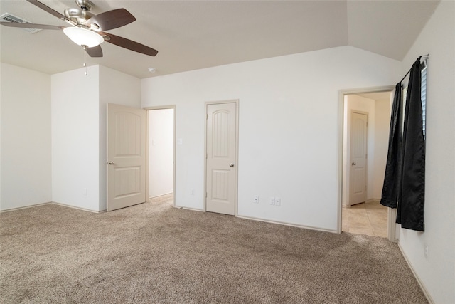 unfurnished bedroom featuring ceiling fan, vaulted ceiling, and light colored carpet