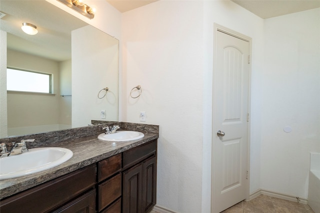 bathroom with vanity, a tub, and tile patterned floors