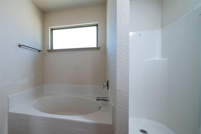 full bathroom with a shower stall and a garden tub