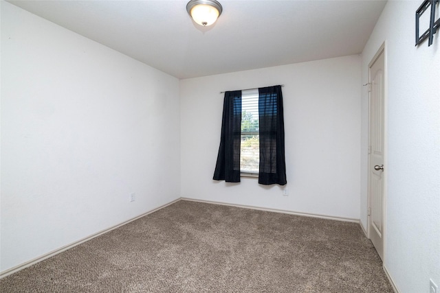 carpeted empty room featuring baseboards