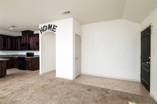 kitchen featuring black appliances, vaulted ceiling, dark brown cabinets, and light colored carpet