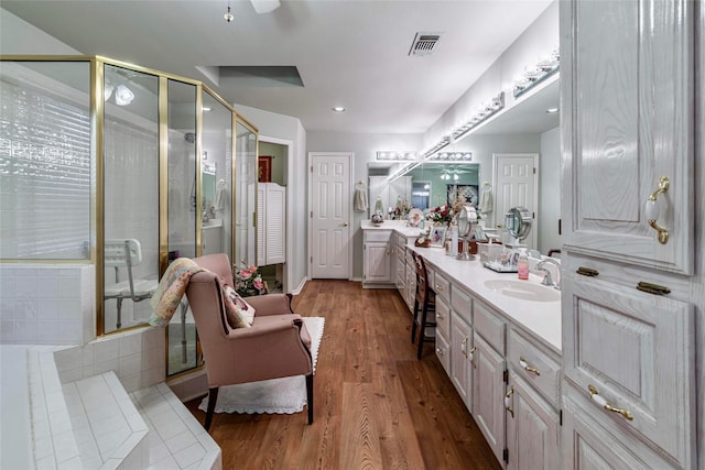 bathroom with hardwood / wood-style floors, vanity, and a shower with door