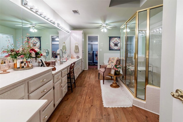 bathroom featuring a shower with door, vanity, and wood-type flooring