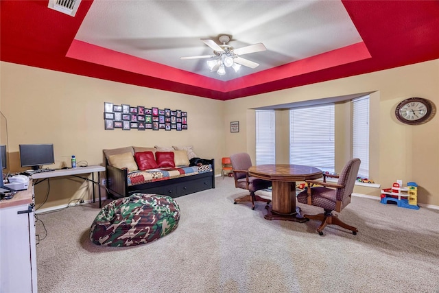 dining room with carpet, a raised ceiling, and ceiling fan