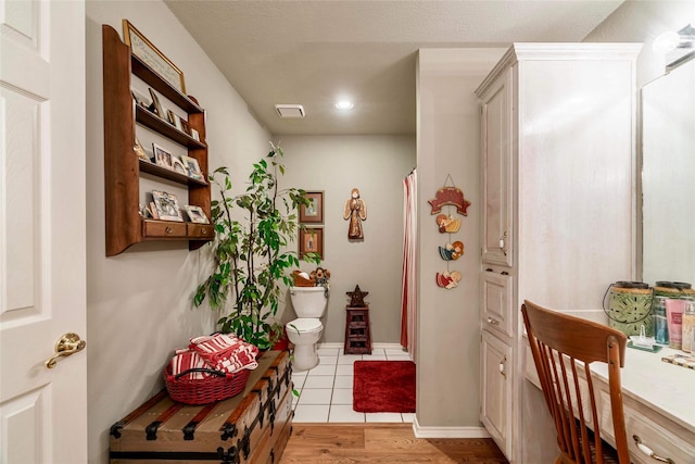 corridor featuring light hardwood / wood-style flooring and a textured ceiling