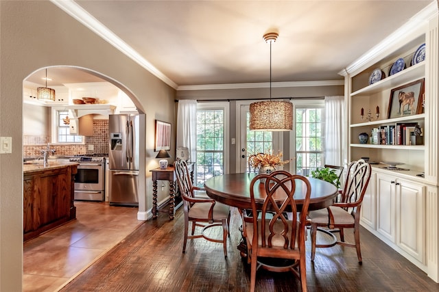 dining space featuring a wealth of natural light, ornamental molding, and dark hardwood / wood-style floors