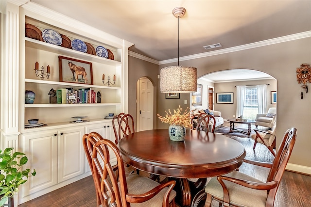 dining room featuring crown molding and dark hardwood / wood-style floors