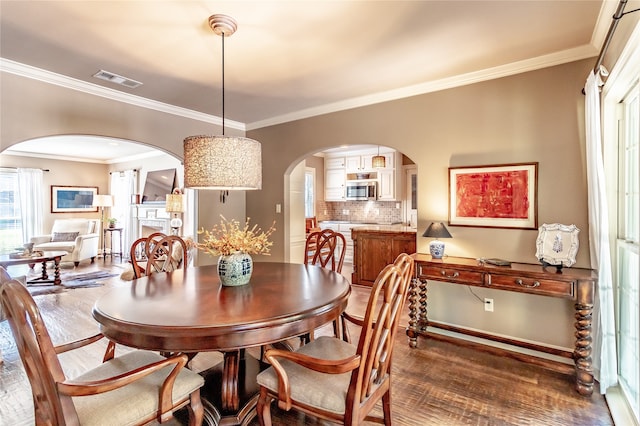 dining area with dark wood-type flooring and ornamental molding