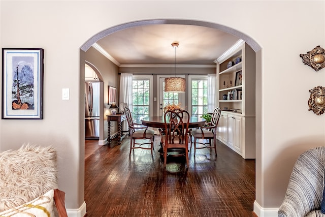 dining area featuring ornamental molding, dark wood-type flooring, and built in features