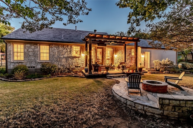 back of property with an outdoor fire pit, a patio area, a yard, and a pergola