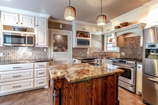 kitchen featuring decorative backsplash, a kitchen island with sink, stainless steel appliances, light stone countertops, and decorative light fixtures