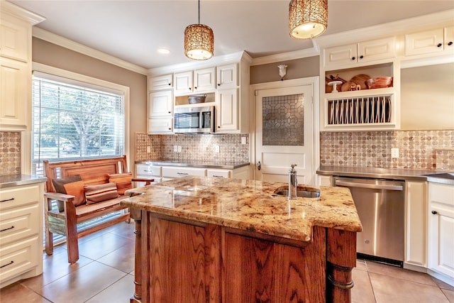 kitchen featuring light stone countertops, sink, an island with sink, stainless steel appliances, and pendant lighting