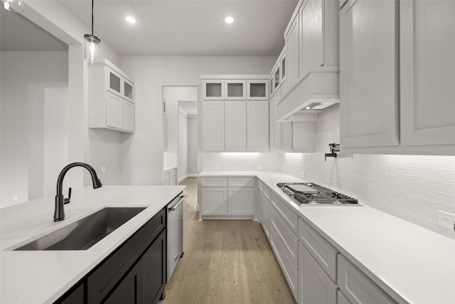 kitchen featuring decorative light fixtures, white cabinets, appliances with stainless steel finishes, and sink