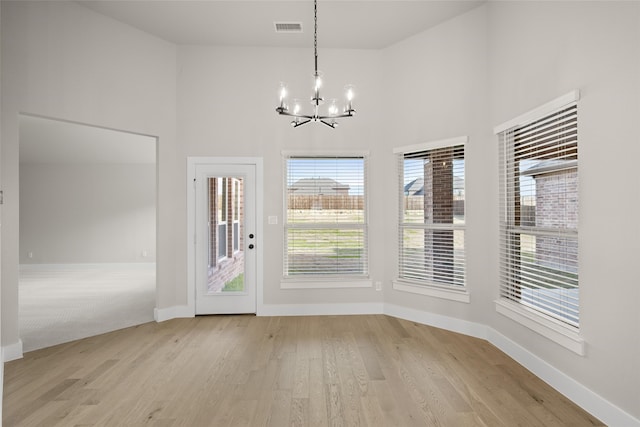 interior space featuring a notable chandelier, a high ceiling, and light hardwood / wood-style floors