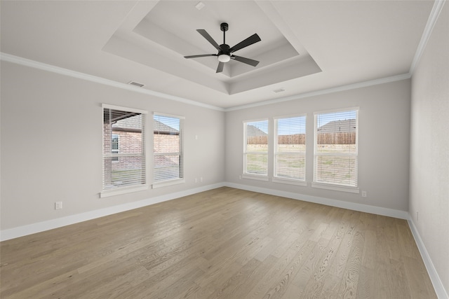 unfurnished room with light wood-type flooring, ceiling fan, crown molding, and a raised ceiling