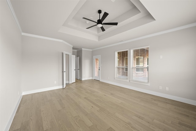 unfurnished room with a raised ceiling, ceiling fan, ornamental molding, and light hardwood / wood-style flooring