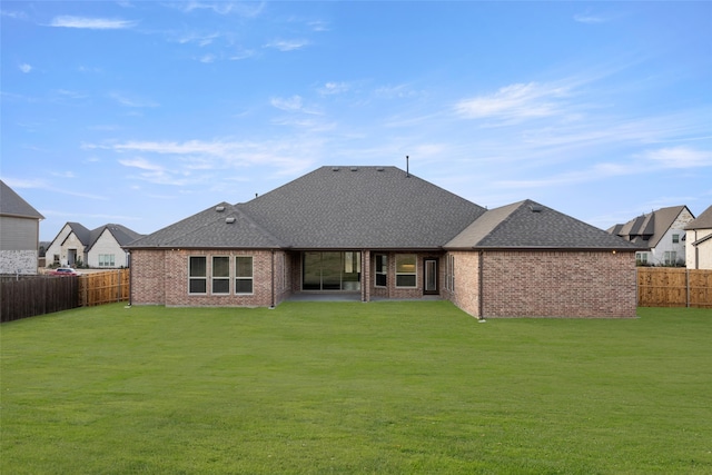 rear view of house featuring a yard