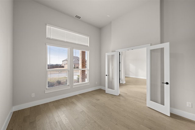 unfurnished room with light wood-type flooring and french doors