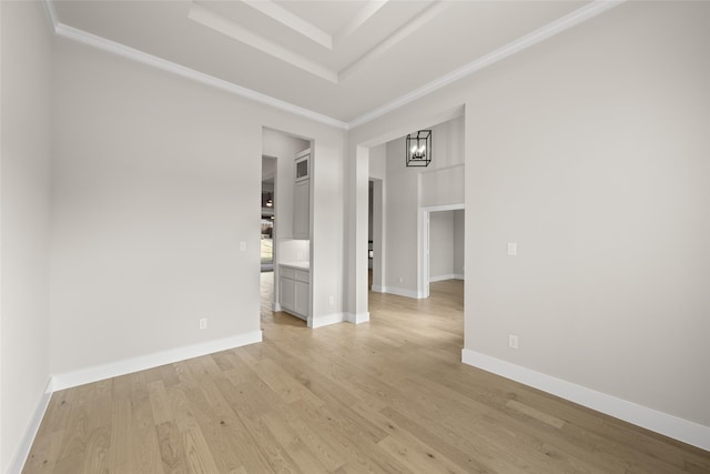 spare room with light hardwood / wood-style floors, a tray ceiling, and a notable chandelier