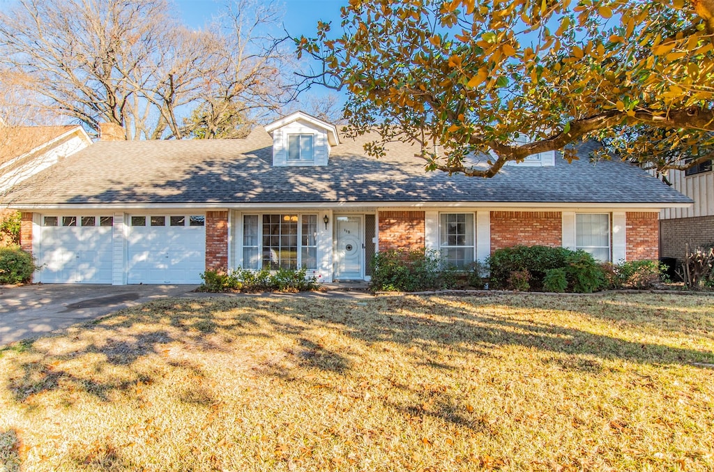 ranch-style house featuring a front lawn and a garage