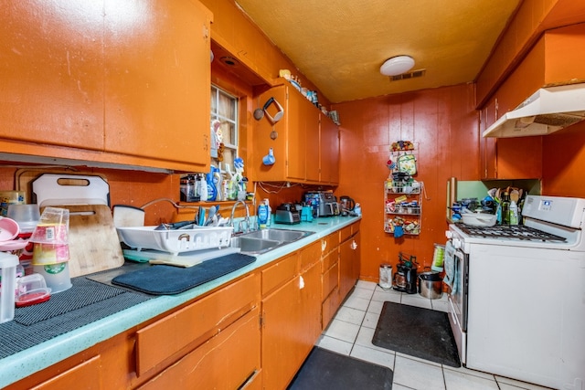 kitchen with sink, white range with gas cooktop, and light tile patterned floors