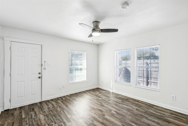 interior space with a wealth of natural light, dark hardwood / wood-style floors, and ceiling fan