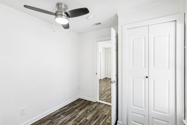 unfurnished bedroom featuring dark hardwood / wood-style flooring, a closet, and ceiling fan