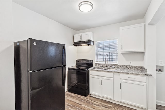 kitchen with light hardwood / wood-style floors, white cabinets, black appliances, and sink